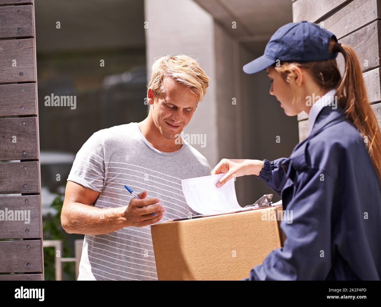 Il arrive toujours à l'heure. Photo d'un messager qui fait une livraison à un client souriant. Banque D'Images