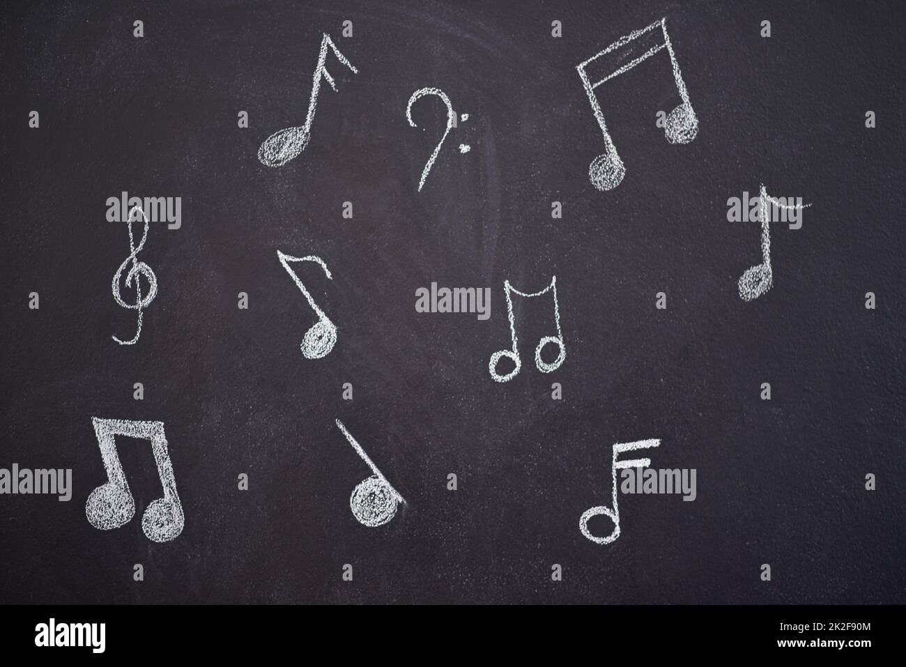 Laissez la musique vous inspirer. Photo de diverses notes musicales dessinées sur un tableau de craie. Banque D'Images
