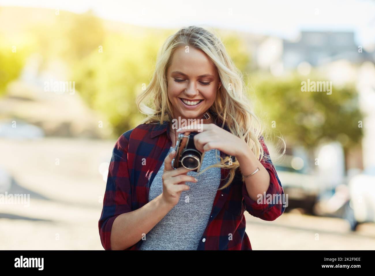 Les photos ont vraiment l'air fantastiques. Prise de vue rognée d'une jeune belle femme regardant des photos sur un appareil photo dans la ville. Banque D'Images