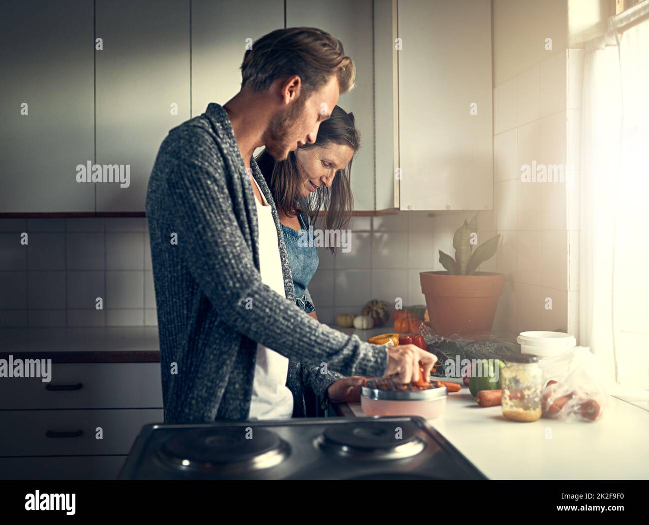 Obtenir des conseils de cuisine de maman. Photo d'une mère et de son fils adulte qui cuisent ensemble dans leur cuisine à la maison. Banque D'Images