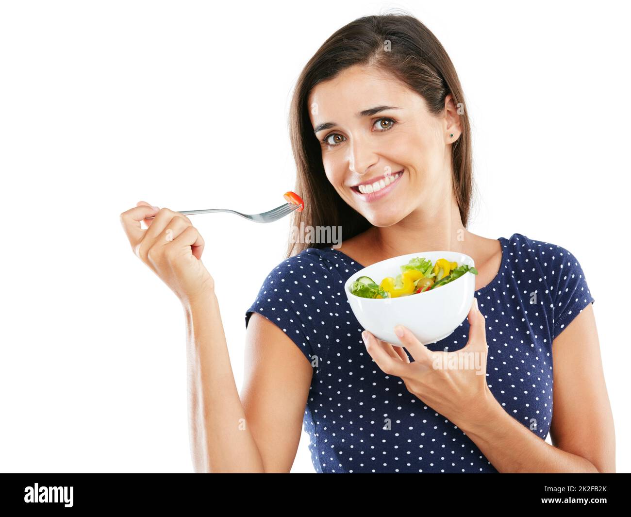 Mangez sainement, sentez-vous bien. Portrait en studio d'une jeune femme attrayante mangeant une salade saine sur fond blanc. Banque D'Images
