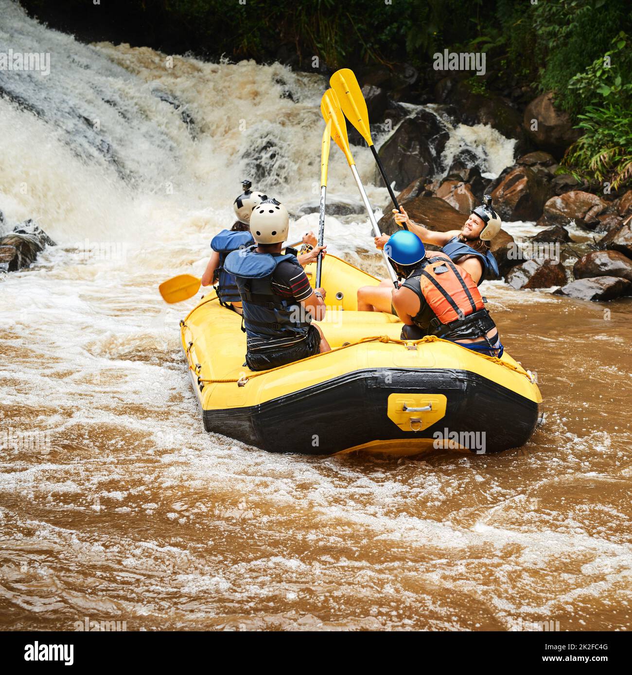 La vie est une question d'expériences. Photo d'un groupe de jeunes amis en rafting en eau vive. Banque D'Images