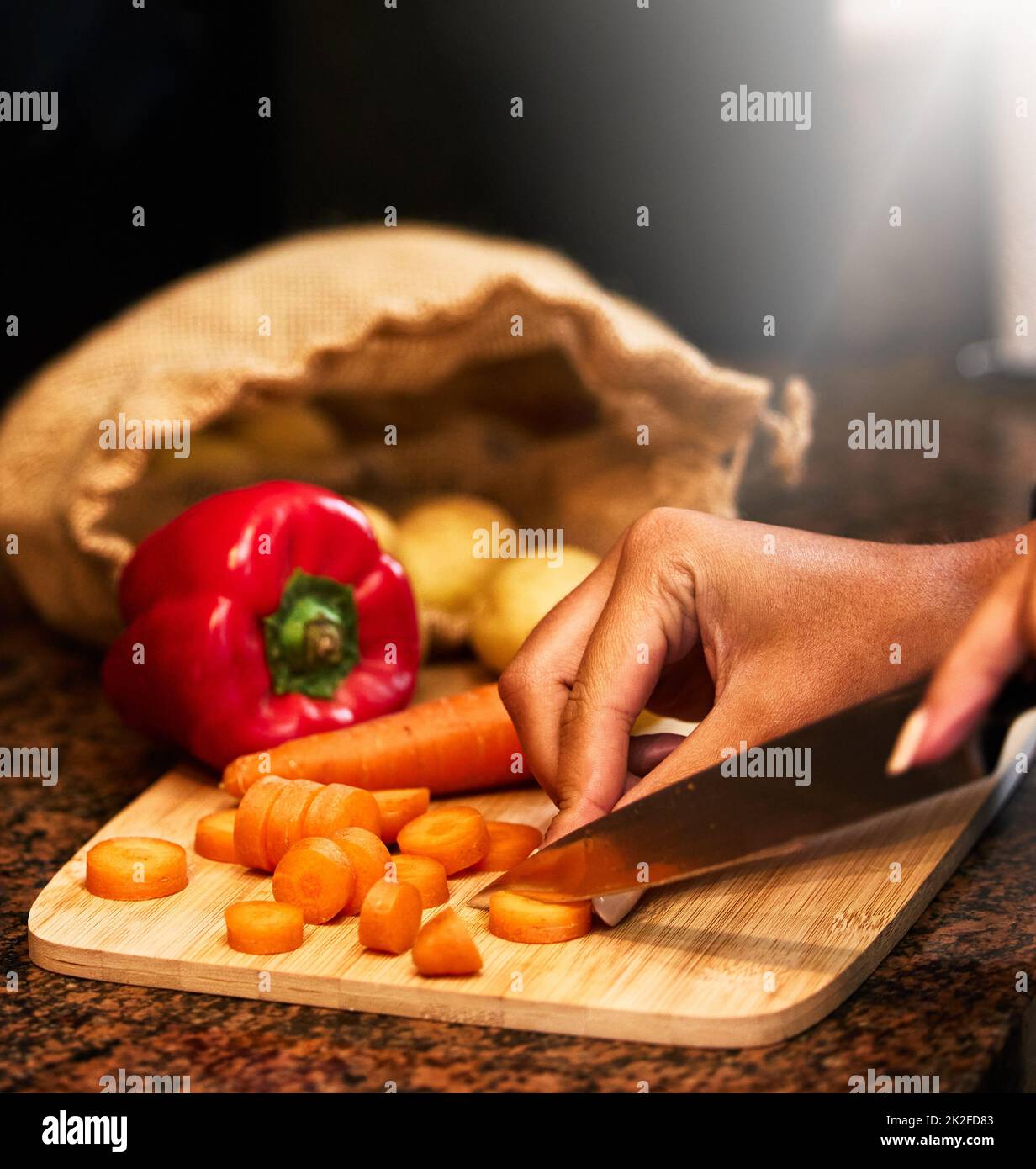 Faites entrer vos légumes du jour. Prise d'une femme hacher des légumes en préparation d'un repas. Banque D'Images