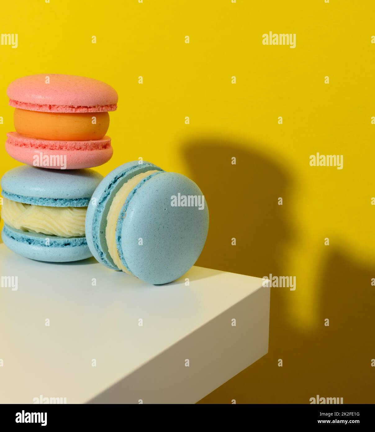 macarons ronds cuits sur fond jaune, délicieux dessert Banque D'Images