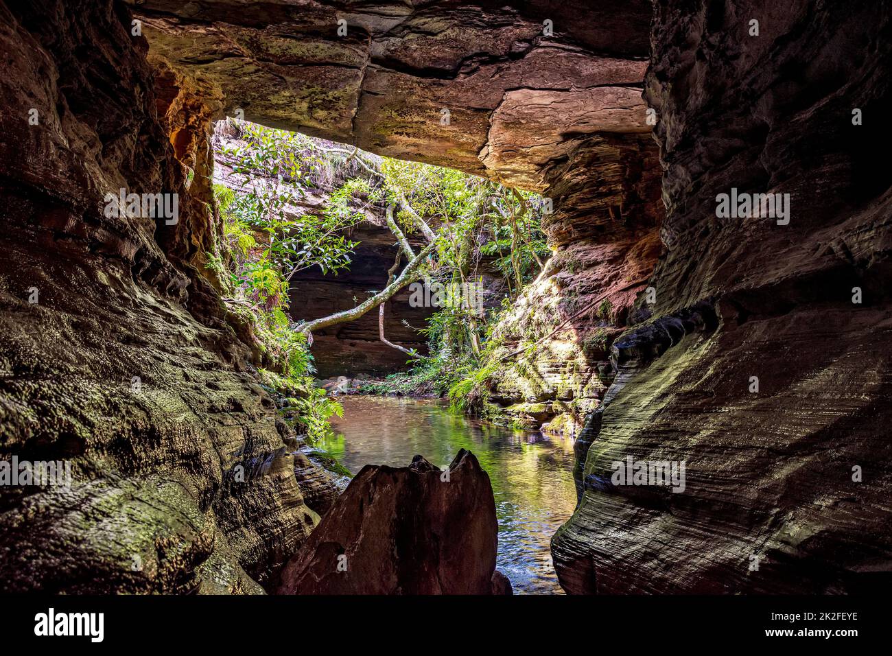 Rivière traversant une grotte en pierre de Carrancas et de la végétation Banque D'Images