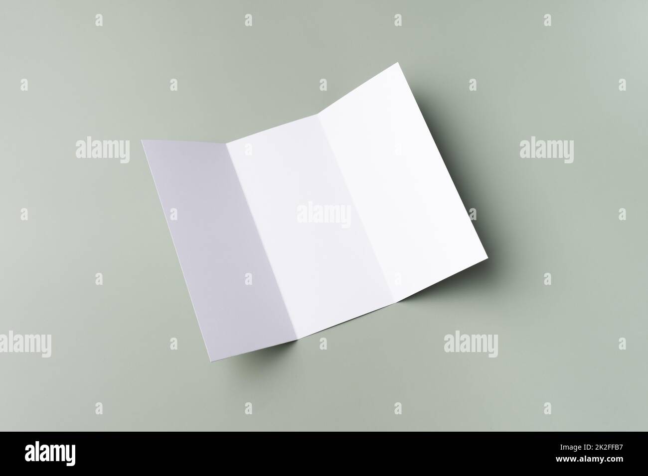 Maquette blanche d'une brochure tripliante blanche sur fond vert pâle. Maquette de carte. Banque D'Images Maquette blanche d'une brochure tripliante blanche sur fond vert pâle. Maquette de carte. Banque D'Images