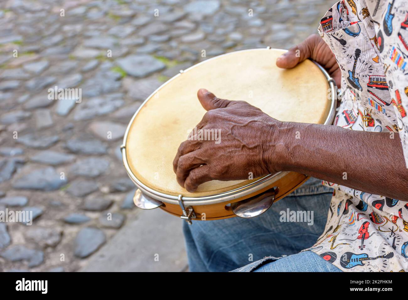 Exécution de Samba avec des mains de musicien jouant du tambourin dans les rues de la ville de Salvador Banque D'Images