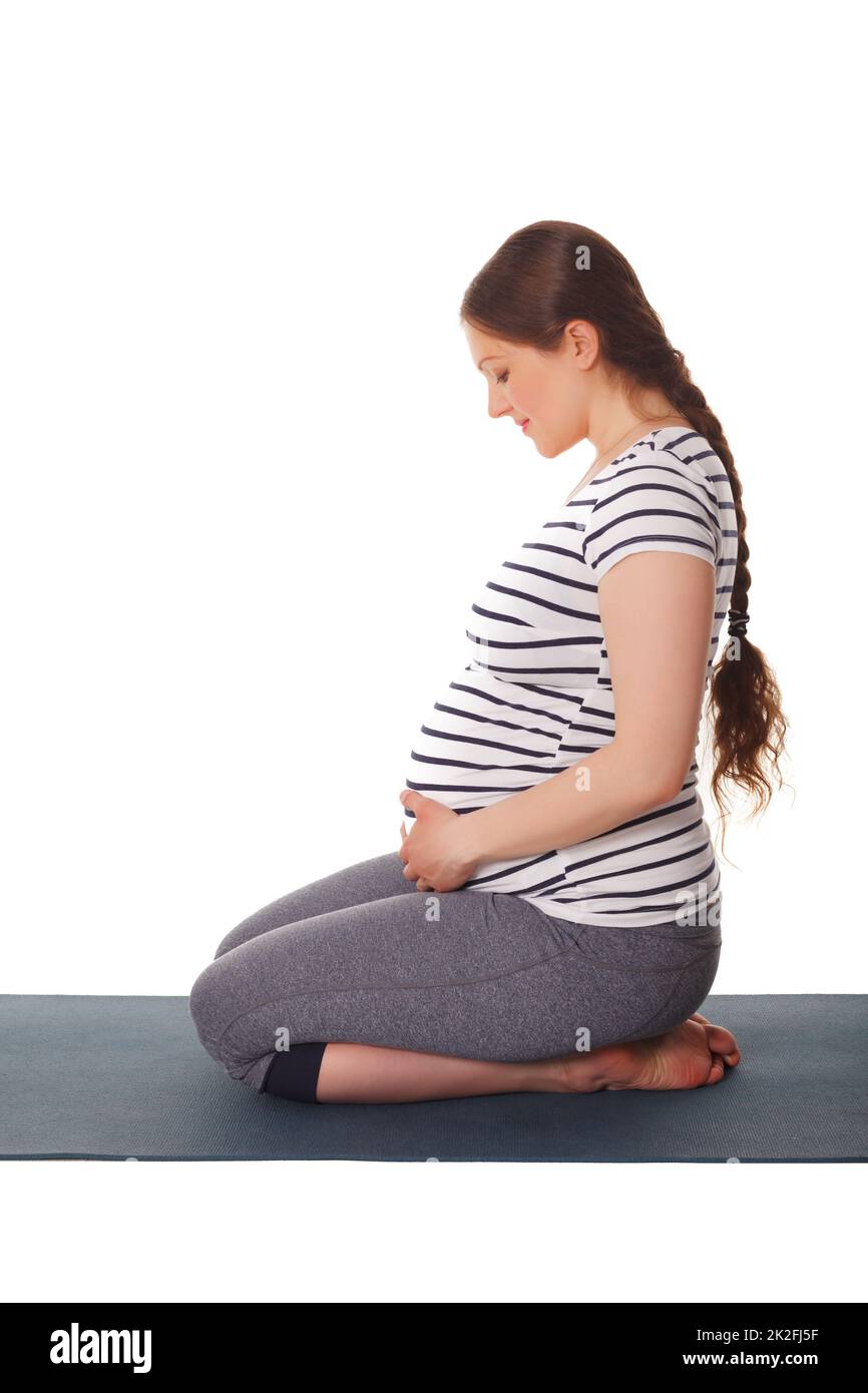 Femme enceinte faisant du yoga asana Virasana Banque D'Images