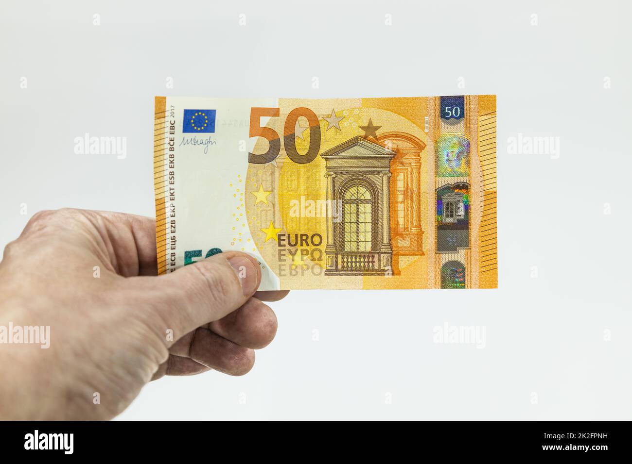 Main d'homme tenant une note de 50 euros Banque D'Images