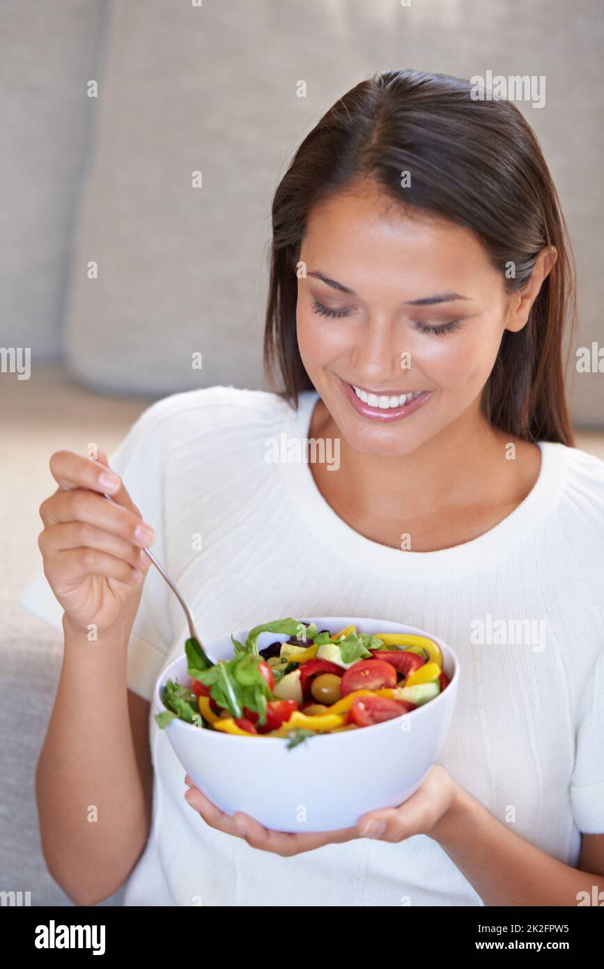 Bonne journée de salade. Une jeune femme attrayante qui profite d'une salade fraîche. Banque D'Images