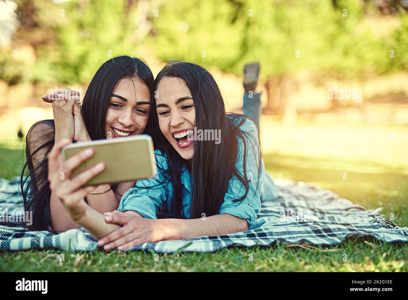 Il faut prendre quelques selfies estival. Photo courte de deux jeunes amis qui prennent un selfie ensemble dans le parc. Banque D'Images
