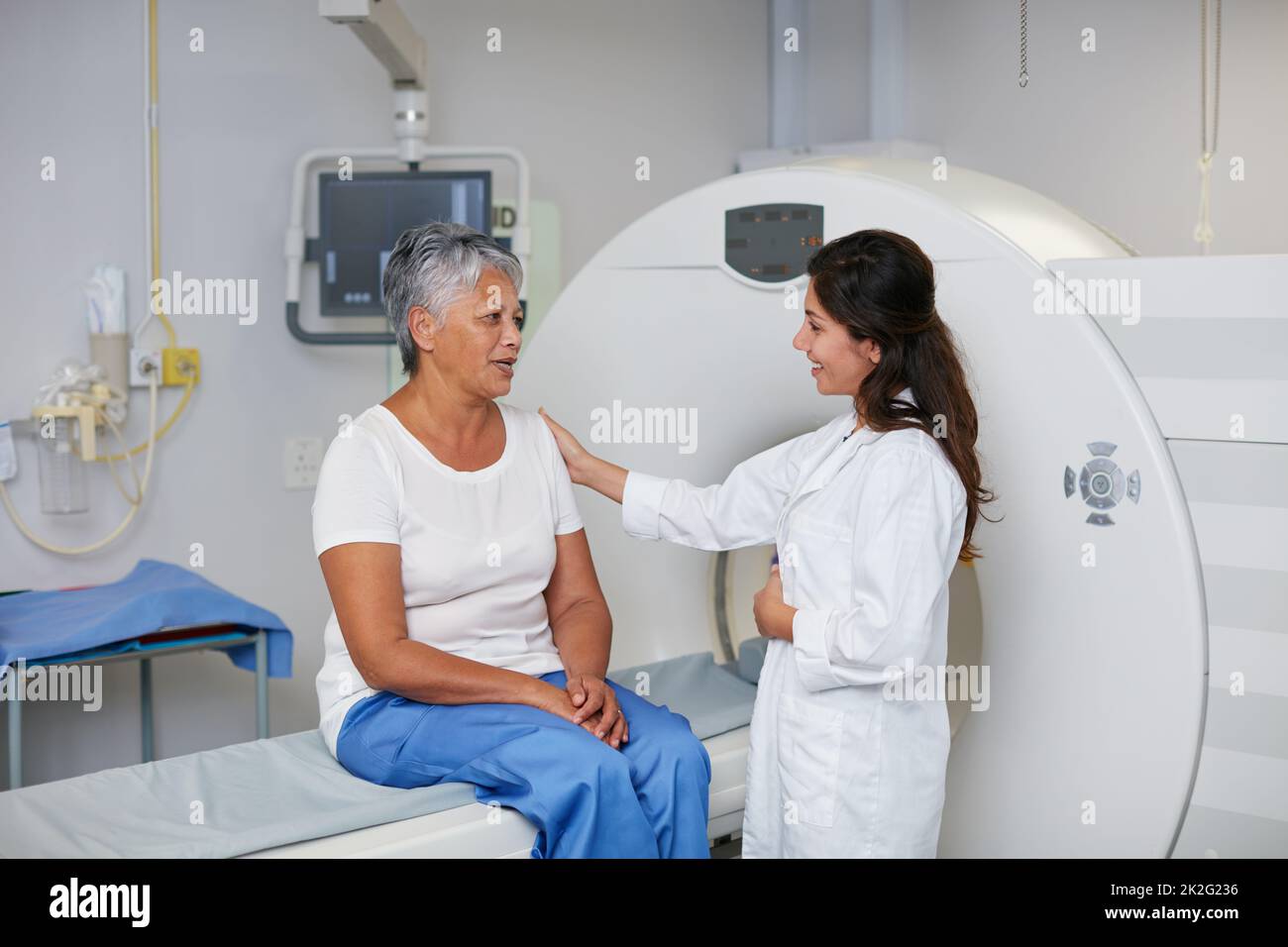 Il s'agit d'une procédure totalement non invasive. Prise de vue d'une femme âgée réconfortée par un médecin avant et IRM. Banque D'Images