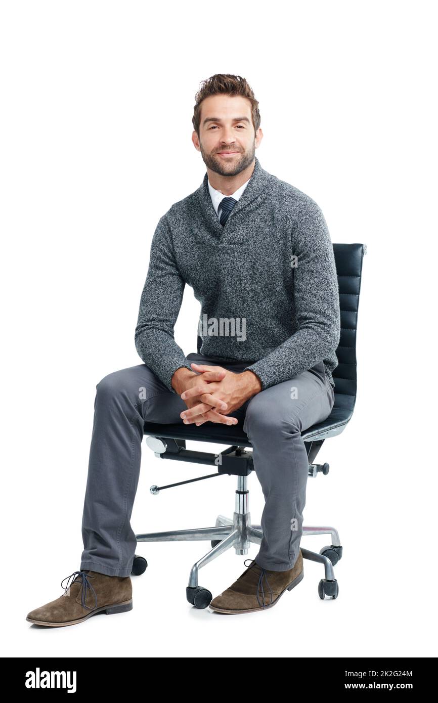 Prenez place, nous avons du travail à faire. Studio portrait d'un homme d'affaires charmant assis sur une chaise sur un fond blanc. Banque D'Images