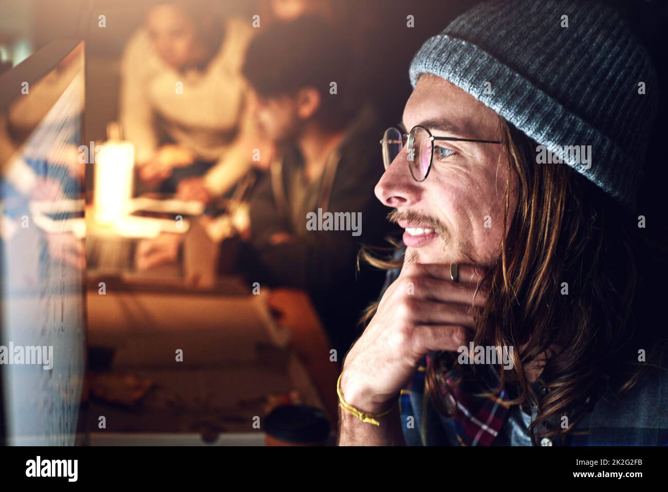 Vue d'ensemble. Photo rognée d'un designer travaillant sur son ordinateur pendant un quart de nuit au travail. Banque D'Images