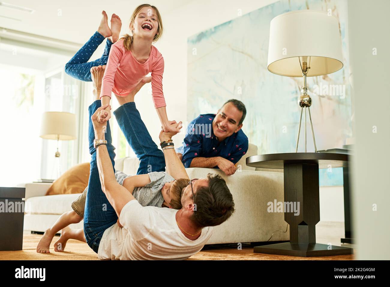 Plus haut, papa. Photo courte d'une adorable petite fille jouant avec son père à la maison. Banque D'Images