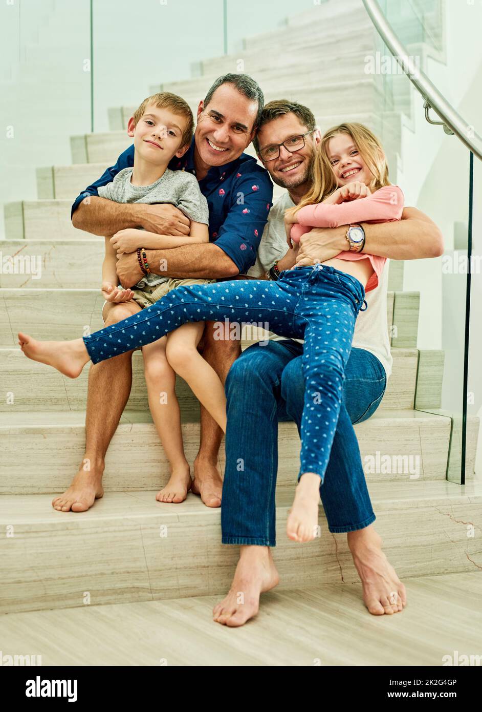 Cette maison est remplie d'amour. Portrait en longueur d'une famille affectueuse de quatre personnes dans les escaliers à la maison. Banque D'Images
