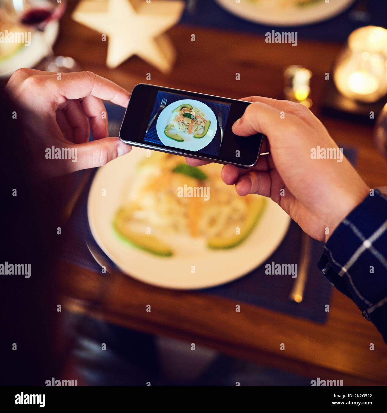 Attendez une photo rapide avant de creuser. Photo d'un homme méconnaissable prenant une photo de la nourriture avec son téléphone portable à la table de la salle à manger. Banque D'Images