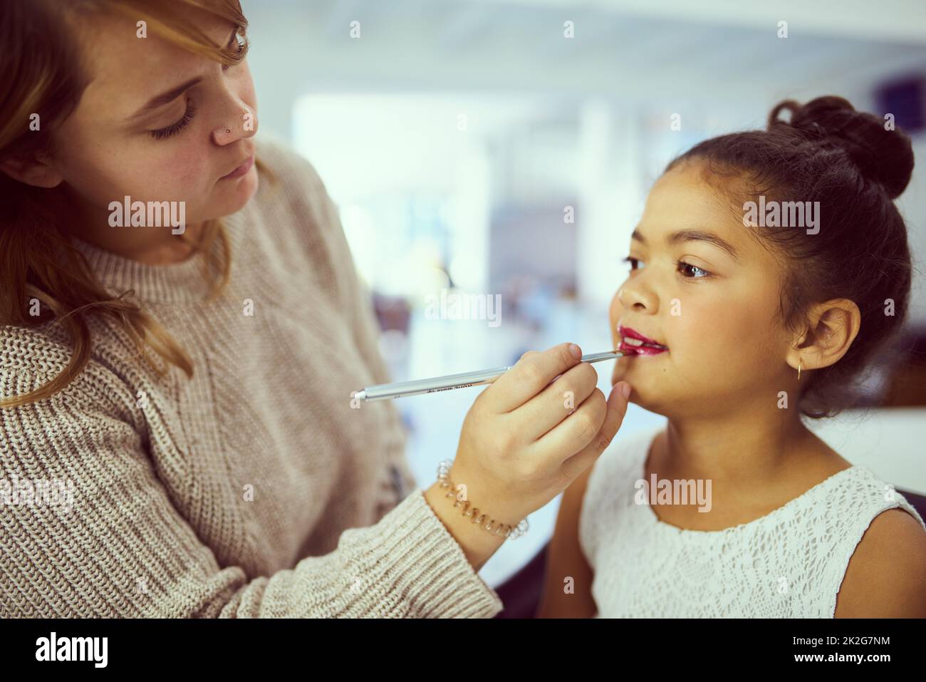 Se préparer à éblouir la foule. Photo d'un styliste appliquant du maquillage à une petite fille mignonne dans un dressing. Banque D'Images