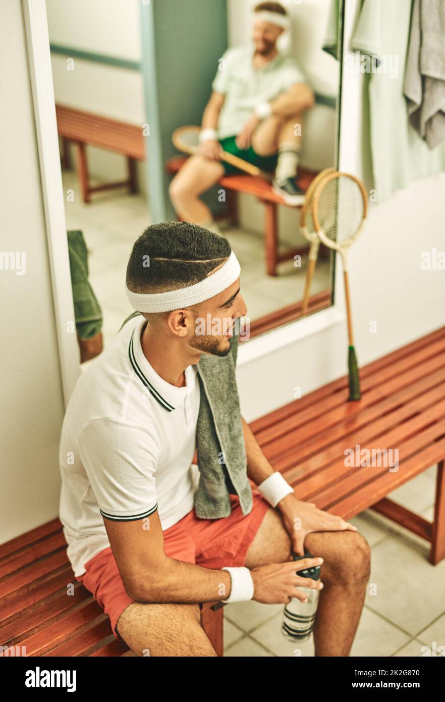Tout sur cette vie de squash. Coup de jeune homme prenant une pause dans le vestiaire après une partie de squash. Banque D'Images