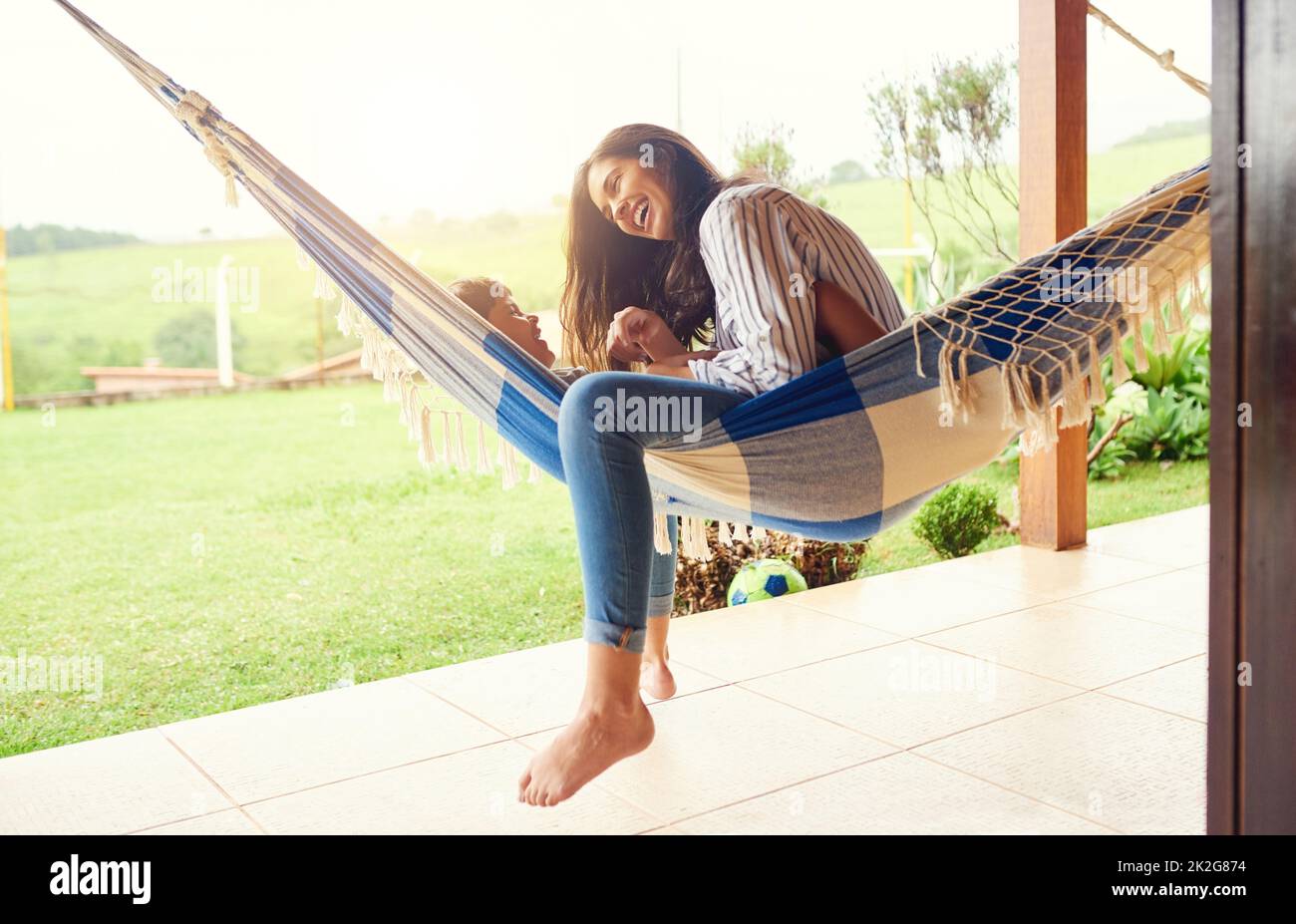 Le bonheur sur un hamac. Plan en longueur d'une jeune femme attrayante et de son fils se liant à l'extérieur sur le hamac. Banque D'Images