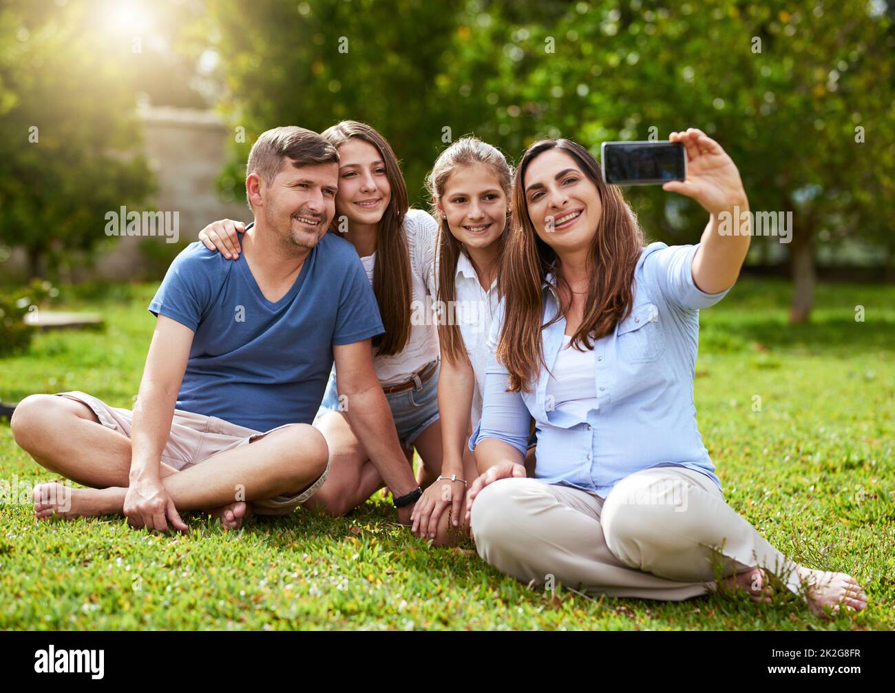 Celui-ci est pour les grands-parents. Photo d'une famille gaie assise dans un parc tout en prenant un autoportrait ensemble à l'extérieur pendant la journée. Banque D'Images