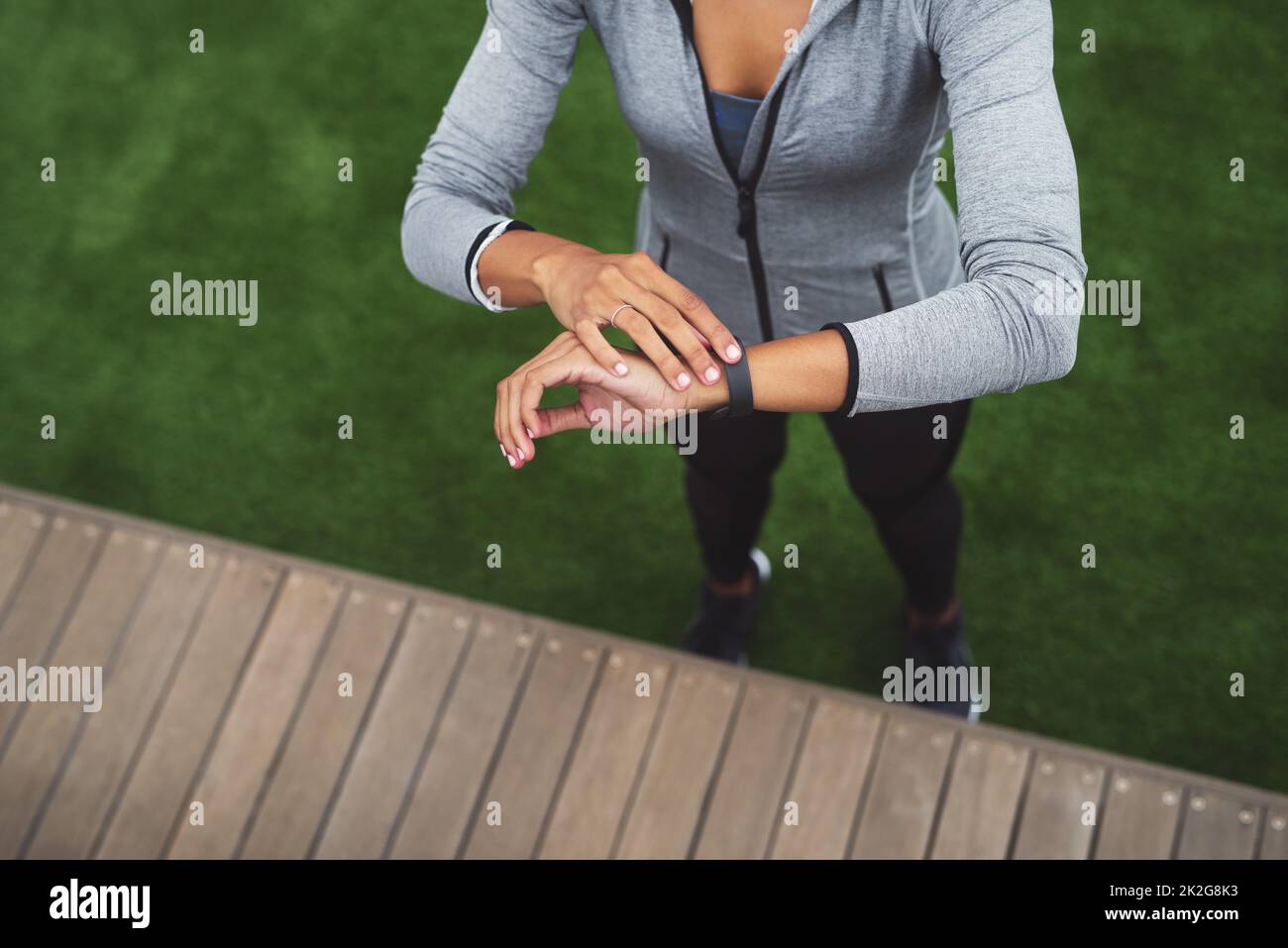 Réservez le temps pour atteindre vos objectifs. Photo en grand angle d'une jeune femme sportive qui vérifie sa montre tout en faisant de l'exercice à l'extérieur. Banque D'Images