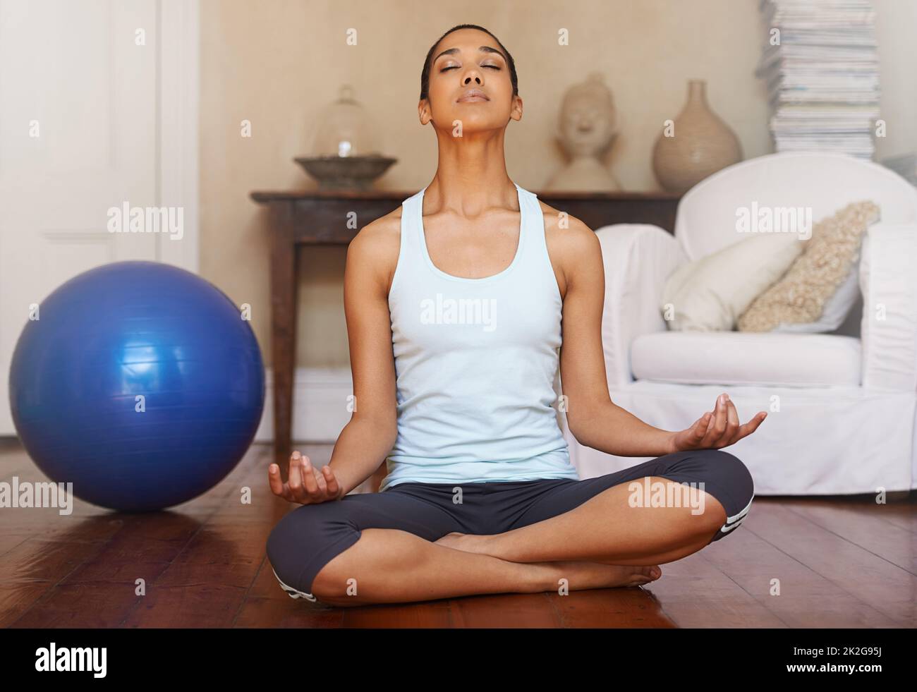 Apporter le corps, l'esprit et l'esprit en harmonie. Prise de vue en longueur d'une jeune femme faisant du yoga à la maison. Banque D'Images