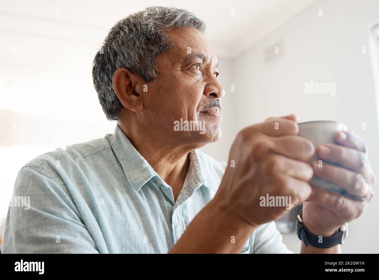 Réflexions sur le café. Photo d'un homme senior qui boit du café à la maison. Banque D'Images