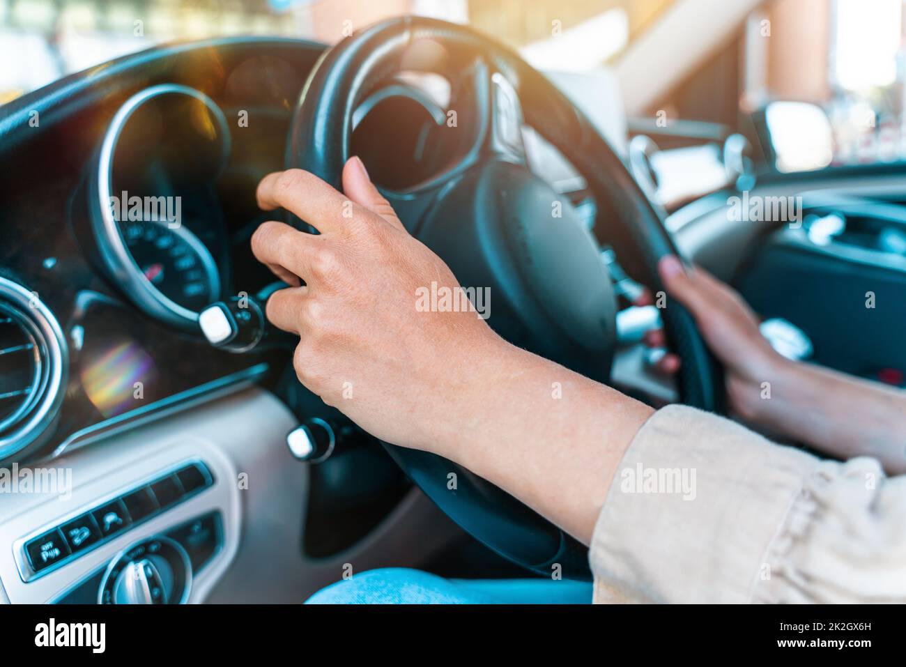 Une femme conduit une nouvelle voiture moderne achetée Banque D'Images