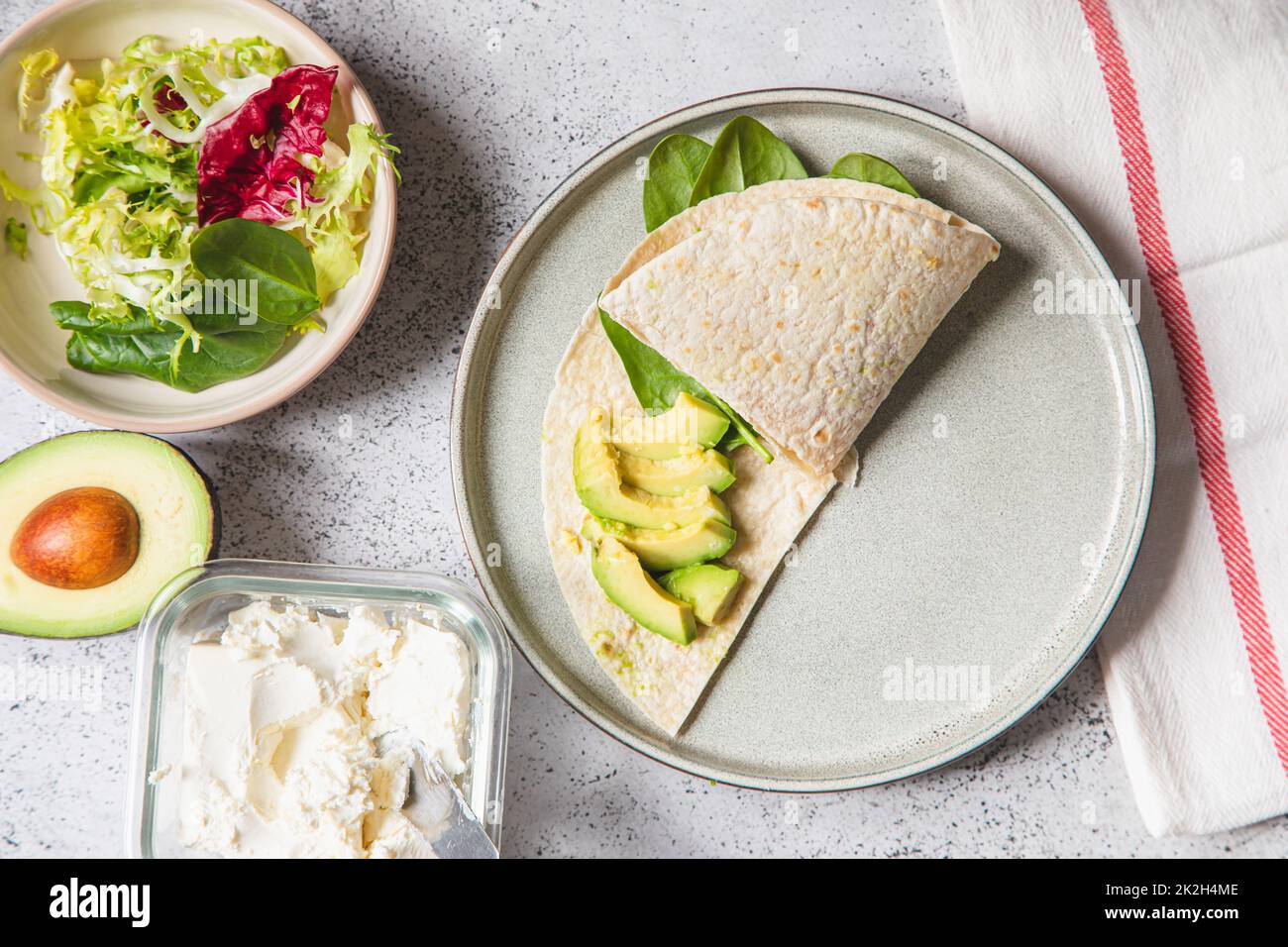 Processus de cuisson des sandwichs et des ingrédients. Préparation de quesadilla avec avocat, saumon, fromage caillé et épinards. Sac à papier à la mode. Étape par étape. Étape 3 Banque D'Images