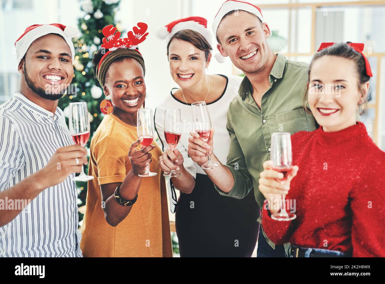 Nous souhaitons à tout le monde une joie et Joyeux Noël. Portrait d'un groupe d'hommes d'affaires créatifs qui boivent du champagne et fêtent ensemble à leur bureau la fête de Noël. Banque D'Images