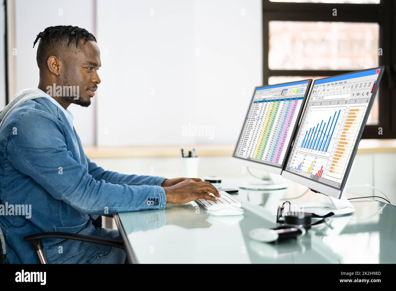 Analyste de données African Man à l'aide de la feuille de calcul Banque D'Images