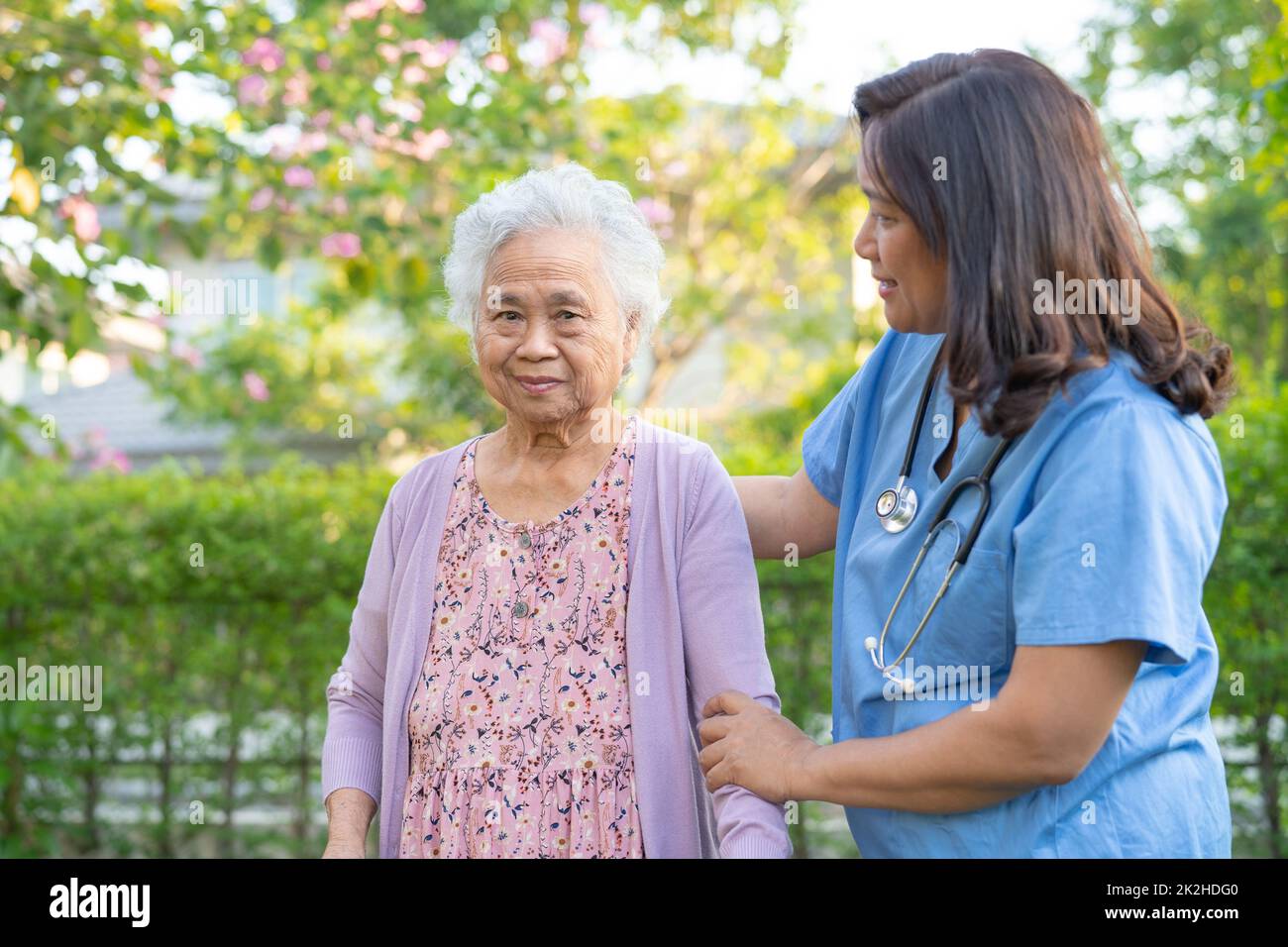 Médecin aide et soins Asian senior ou âgée femme utilisation de marcheur avec une bonne santé tout en marchant au parc dans de bonnes vacances fraîches. Banque D'Images