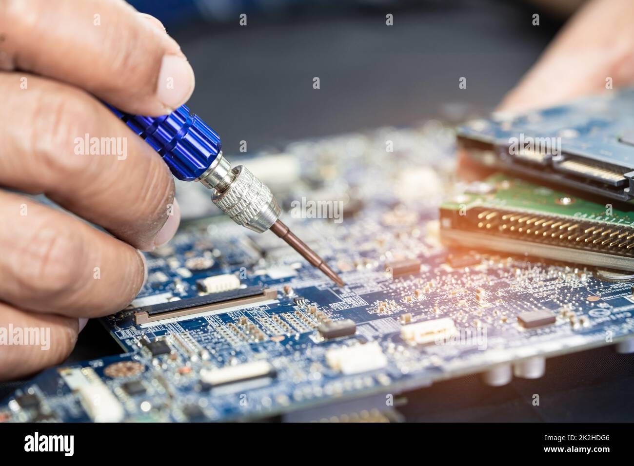 Technicien réparant l'intérieur de la carte de circuit imprimé par fer à souder. Circuit intégré. le concept de données, de matériel, de technicien et de technologie. Banque D'Images