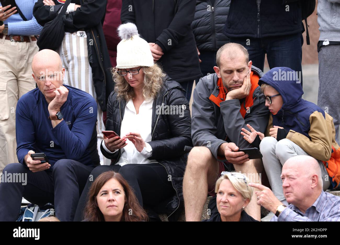 People watch the television coverage on their mobile phones. The State