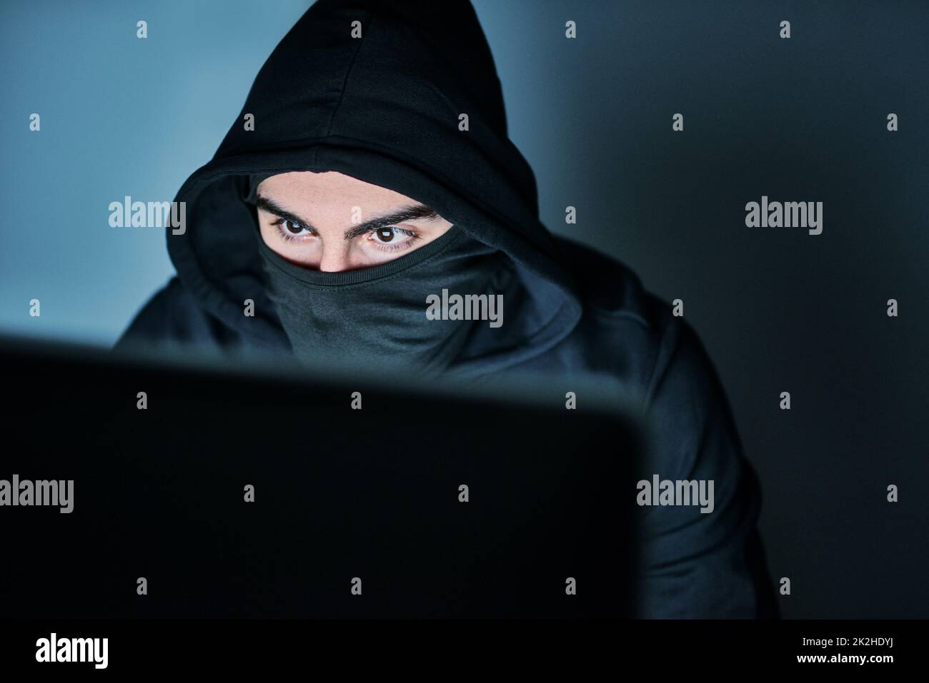 HES à la recherche de vos mots de passe. Photo d'un jeune hacker utilisant un ordinateur tard dans la nuit. Banque D'Images