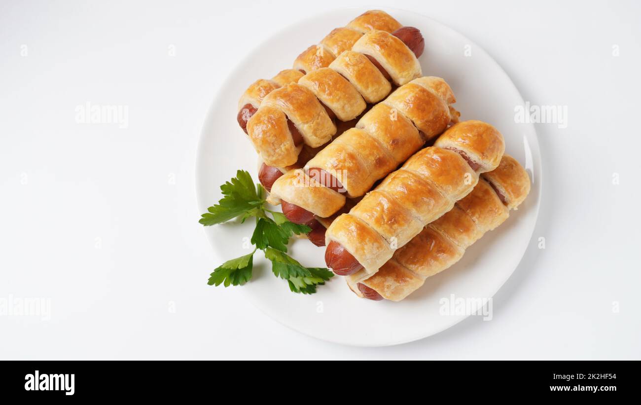 Petits pains à saucisse. Pain cuit au four (pâte) farci avec des saucisses pour le petit déjeuner ou la pause-café. Petit pains à saucisse (hot dog). Banque D'Images