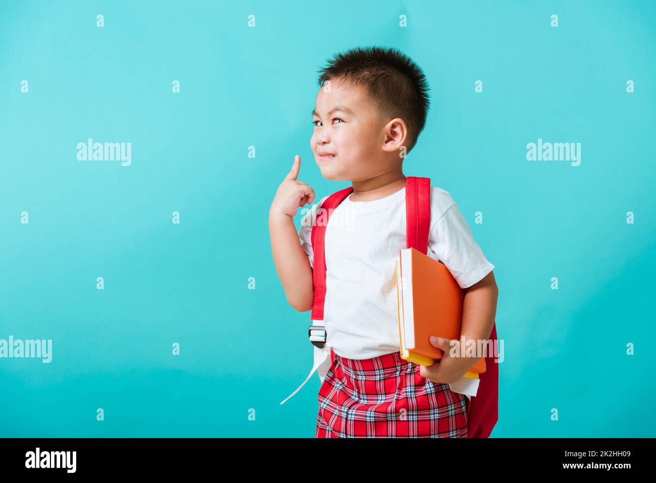 Enfant de la maternelle avec livre et sac d'école Banque D'Images