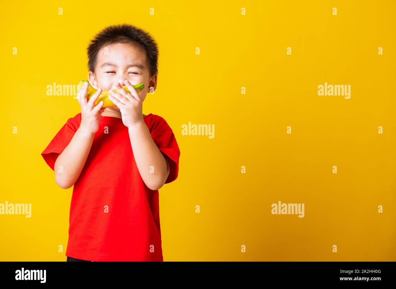 enfant ou enfant mignon petit garçon beau sourire jouant contient des fruits de banane Banque D'Images