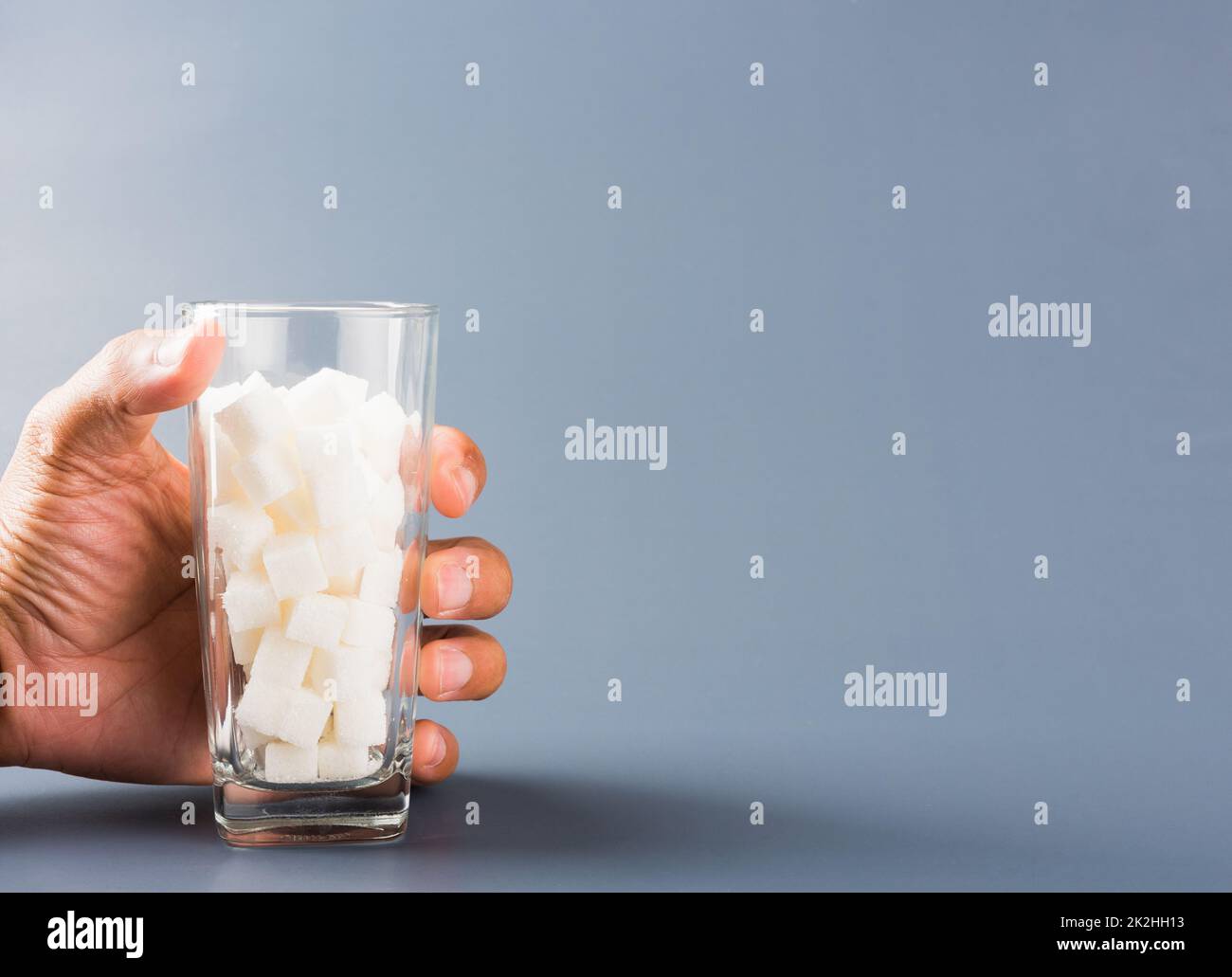 Poignée sur un verre rempli de cube de sucre blanc Banque D'Images