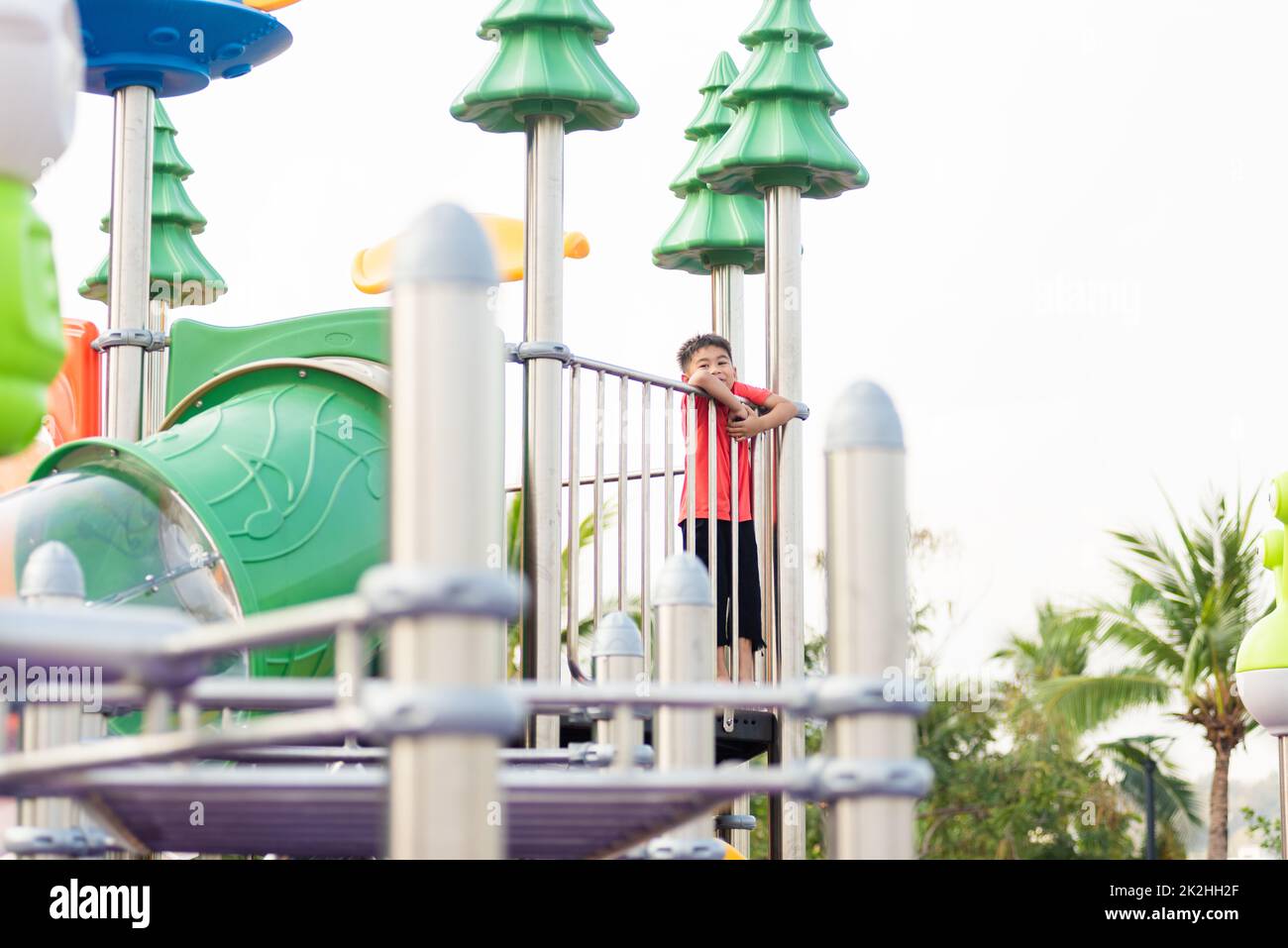 enfants jouant sur l'aire de jeux en plein air, joyeux petit enfant d'âge préscolaire ayant drôle tout en jouant sur l'aire de jeux Banque D'Images