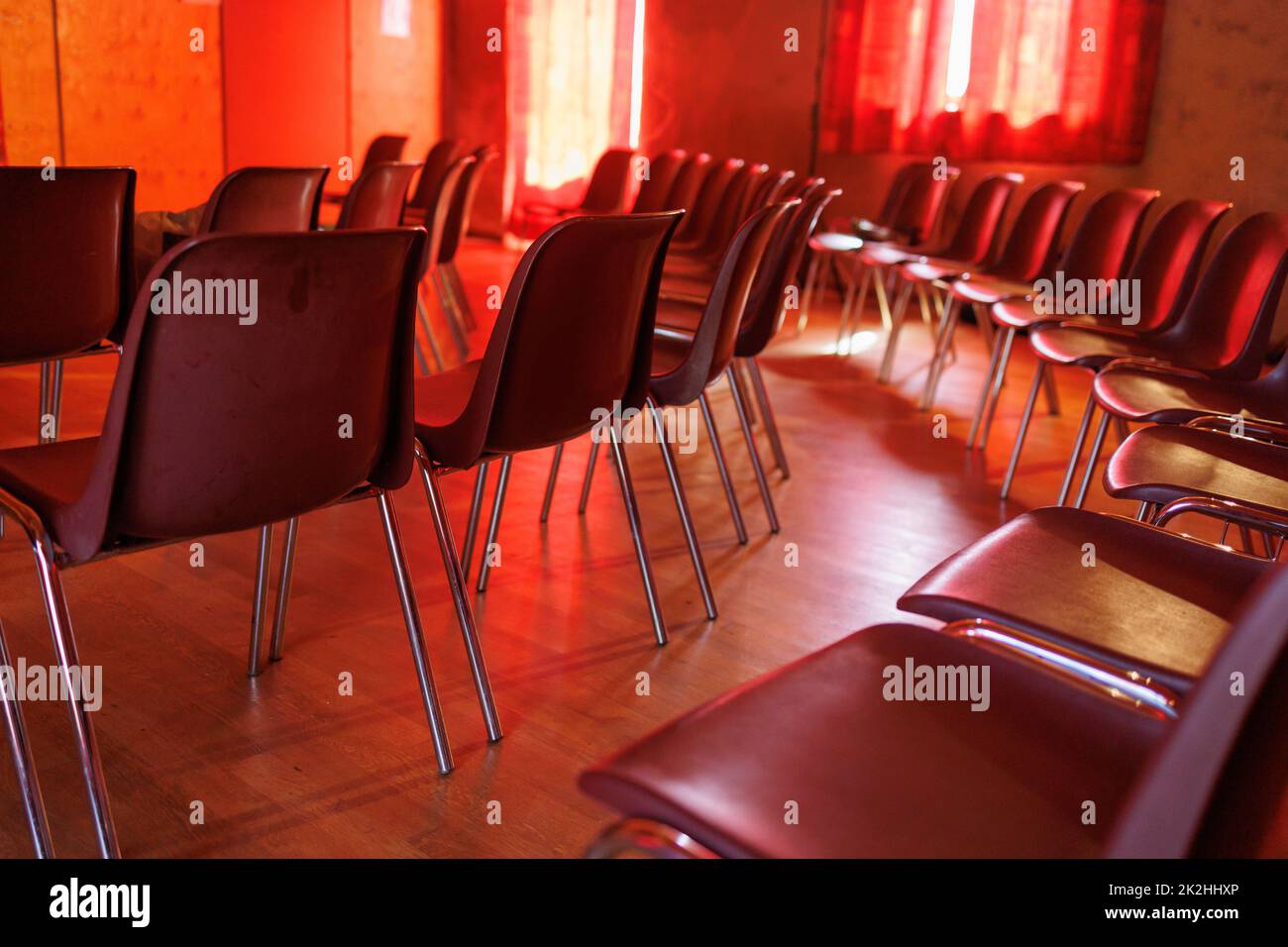 Salle de réunion avec chaises et sièges. Lieu de l'événement dans une ambiance rouge Banque D'Images