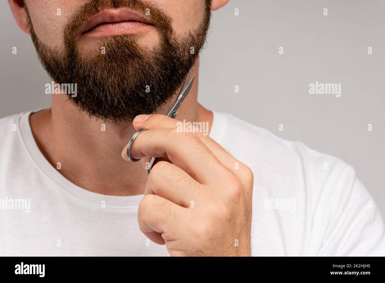 Homme tailler sa barbe avec des ciseaux Banque D'Images