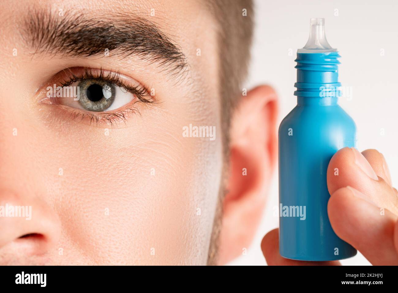 Œil mâle et petite bouteille d'eyedrops Banque D'Images