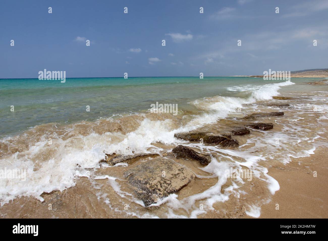 Plage sauvage, aux vagues de la mer petits rochers sur le sable, l'eau