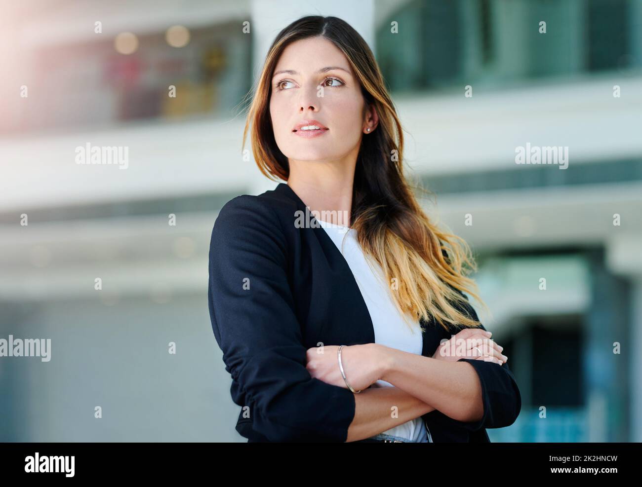 Elle a beaucoup de pensées à l'esprit. Photo courte d'une jeune femme d'affaires attirante et attentionnée debout, les bras croisés dans un bureau moderne. Banque D'Images