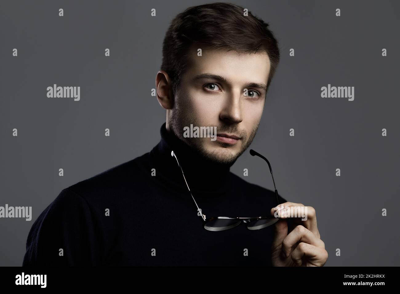 Jeune homme intelligent portant un col de cygne et des lunettes Banque D'Images