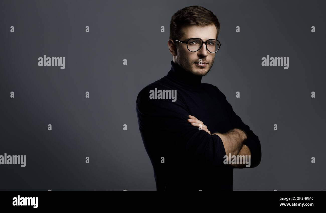 Jeune homme intelligent portant un col de cygne et des lunettes Banque D'Images