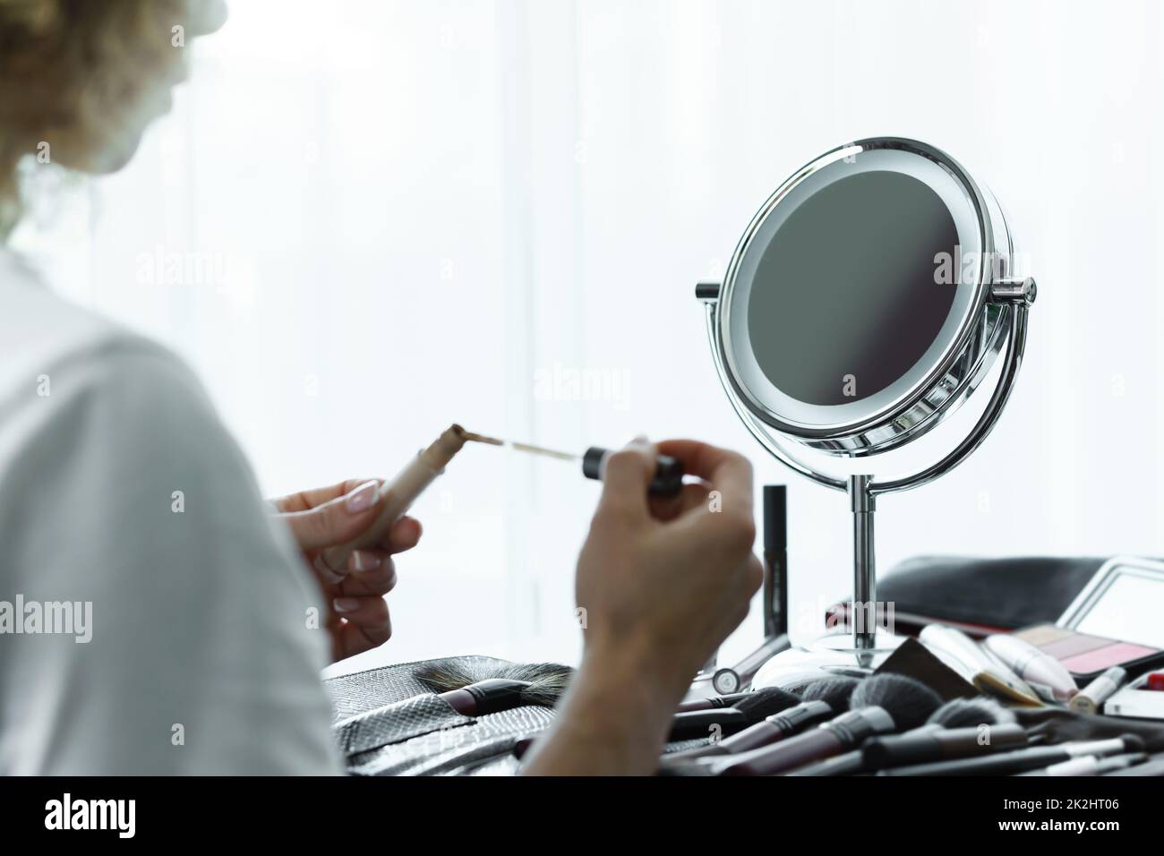 Miroir rond pour maquillage et mains femelles avec un correcteur liquide Banque D'Images