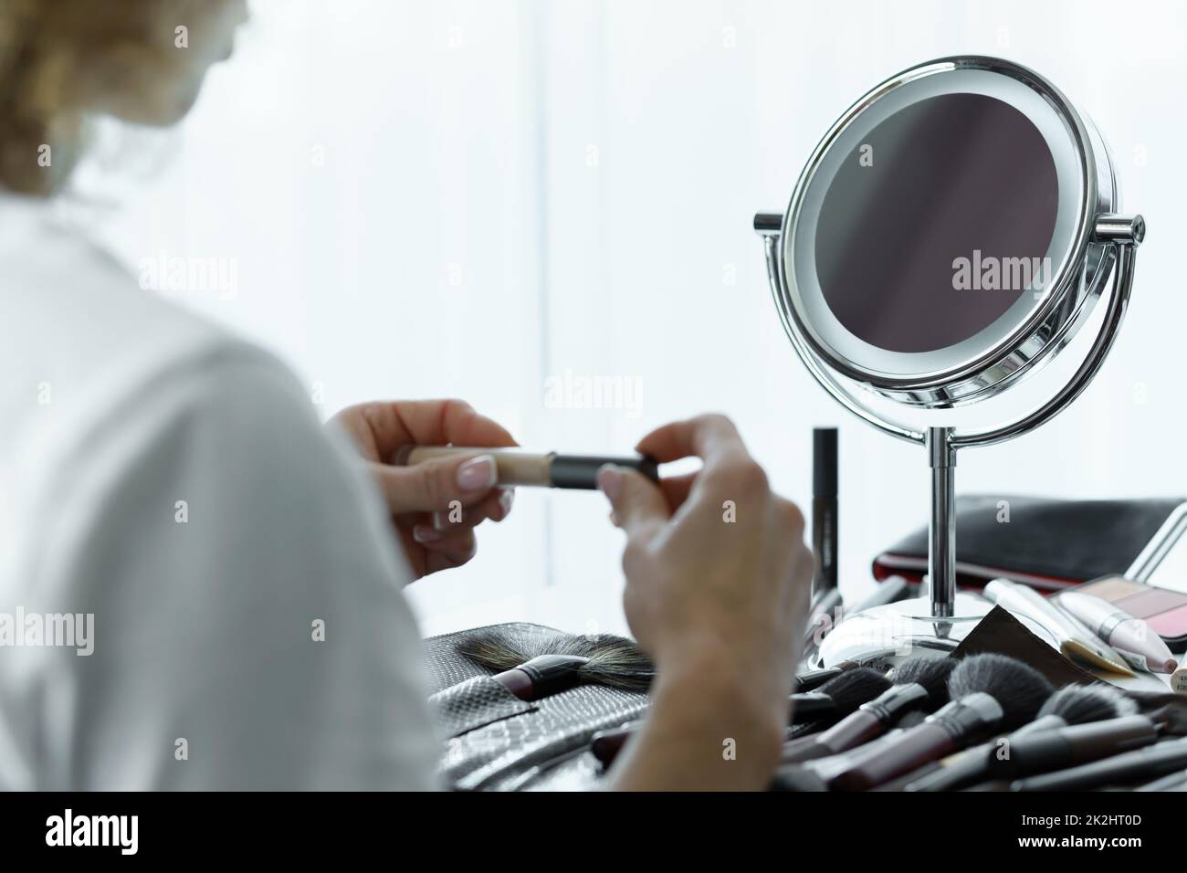 Miroir rond pour maquillage et mains femelles avec un correcteur liquide Banque D'Images